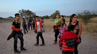 Migrants from Guatemala turn to face a local law enforcement official, not shown, giving them instructions after they crossed the Rio Grande near McAllen, Texas, in 2014. (Credit: Michael Robinson Chavez/Los Angeles Times)